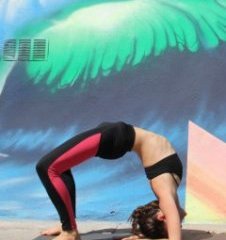A female yoga teacher in forearm wheel yoga pose