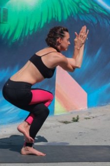 A female yoga teacher in eagle yoga pose