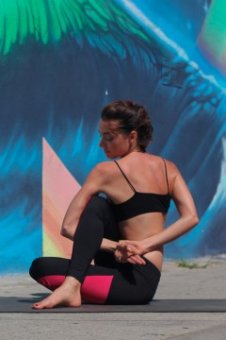 A female yoga teacher in sage twist yoga pose