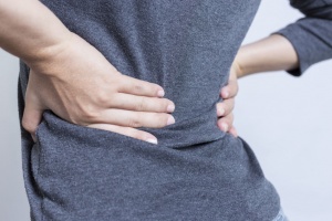 Woman holding her low back region having pain